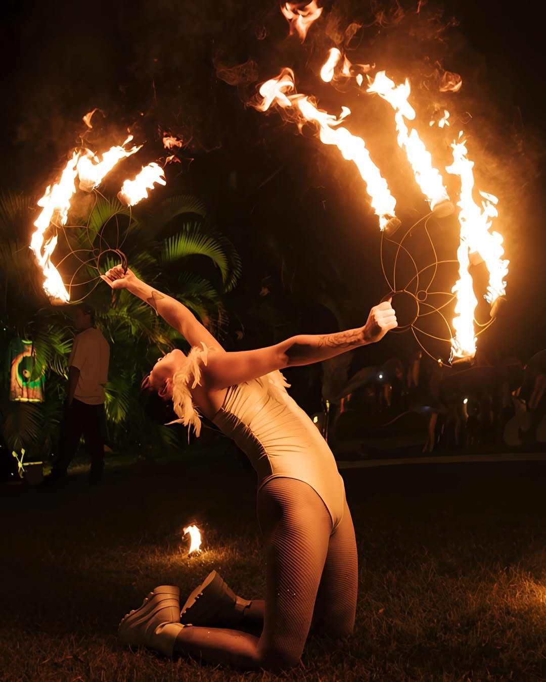 Fire performer JAWARA moving with fire fans above her head